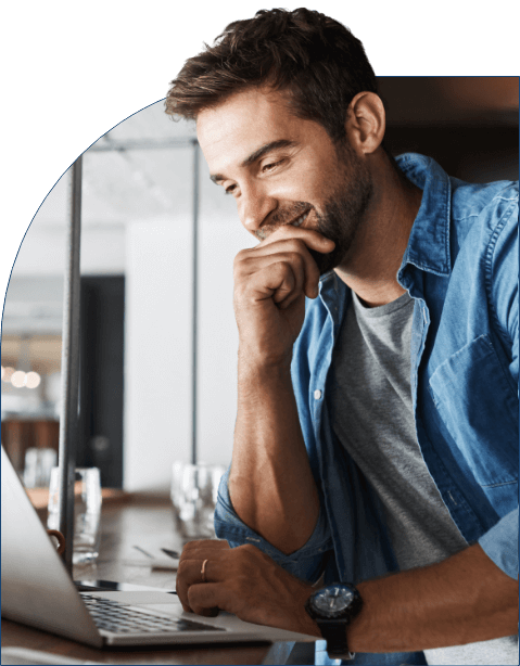 smiling man looking at his laptop